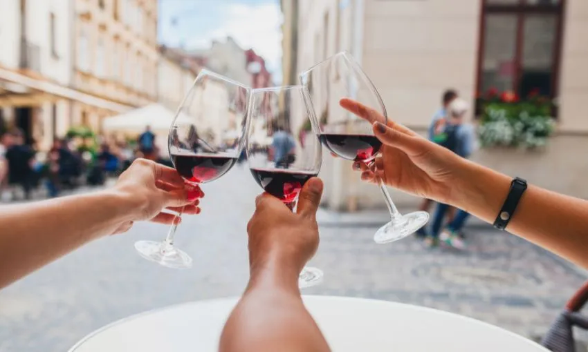 tre braccia, con 3 calici di vino che fanno un brindisi