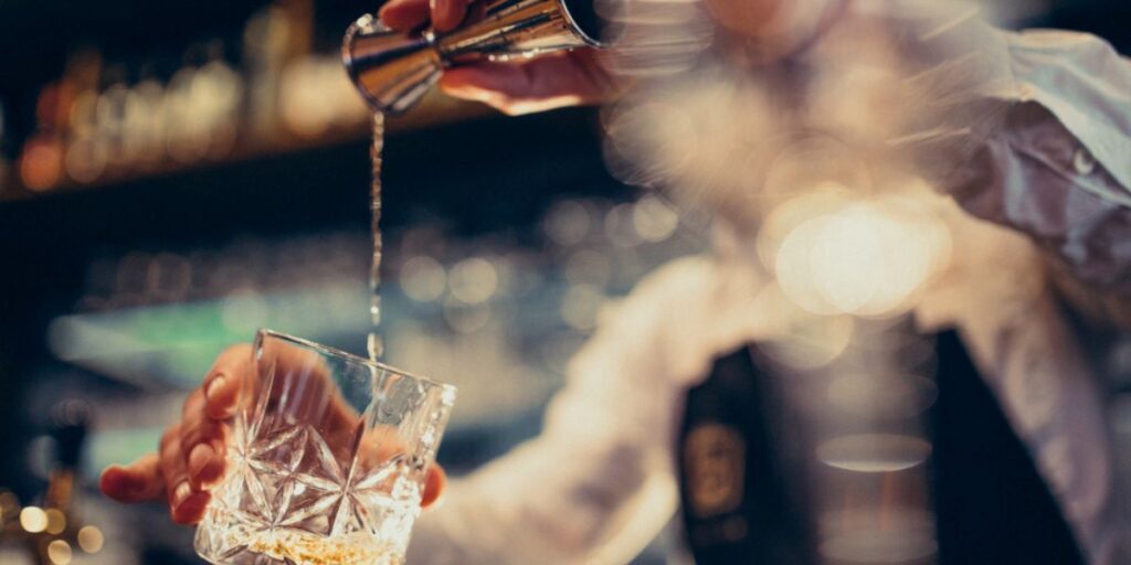 barista che versa gin